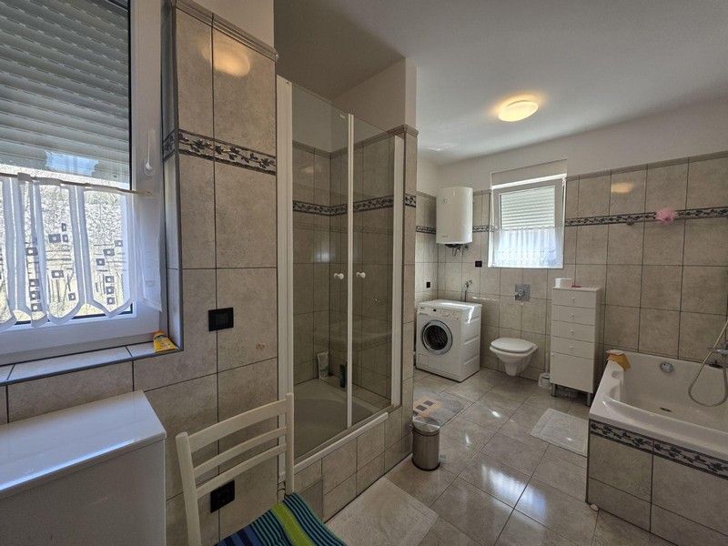 Ampio bagno con doccia, vasca da bagno e lavatrice