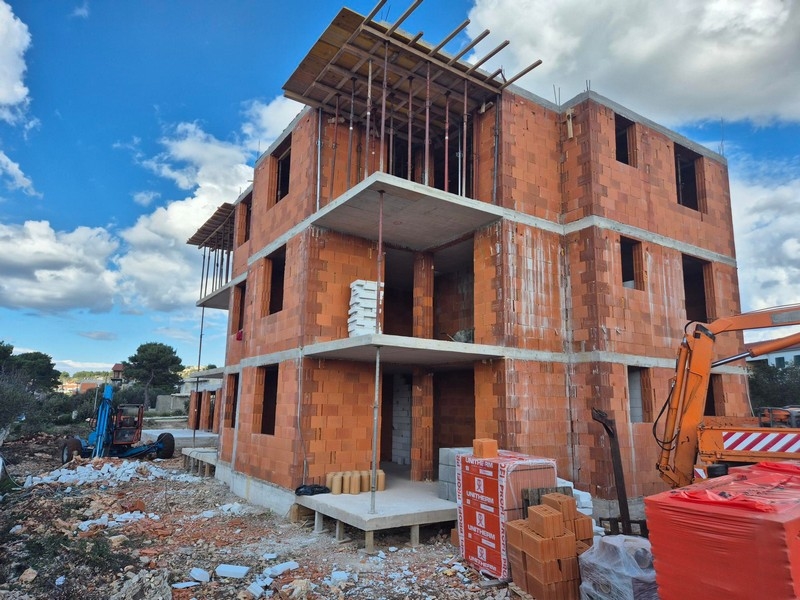 Vista esterna di una palazzina in costruzione con mattoni rossi