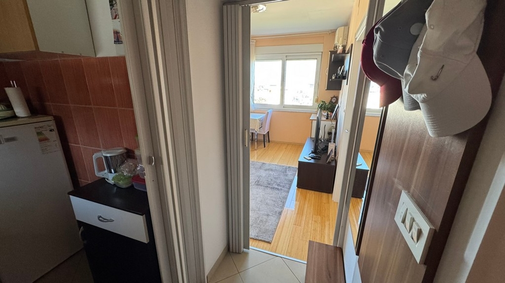 Ingresso con vista sul soggiorno e blocco cucina a sinistra