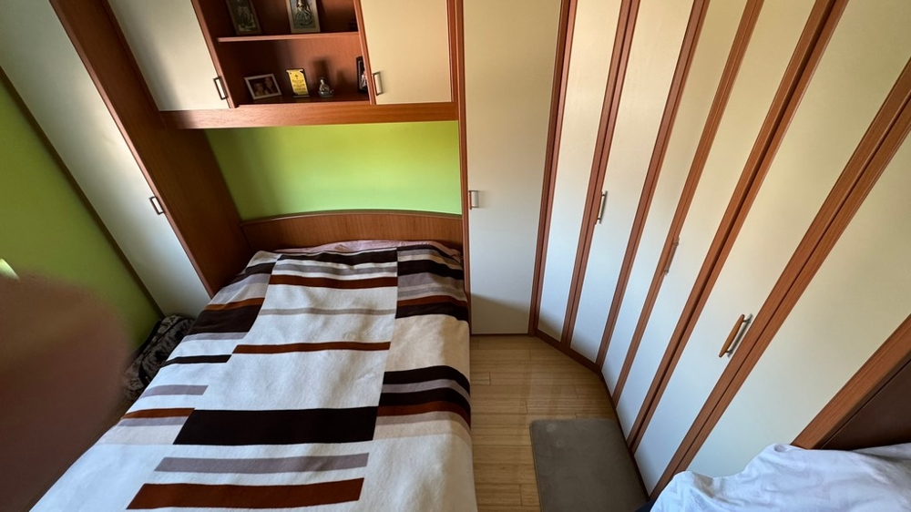 Camera da letto con armadio e vani portaoggetti sopra il letto