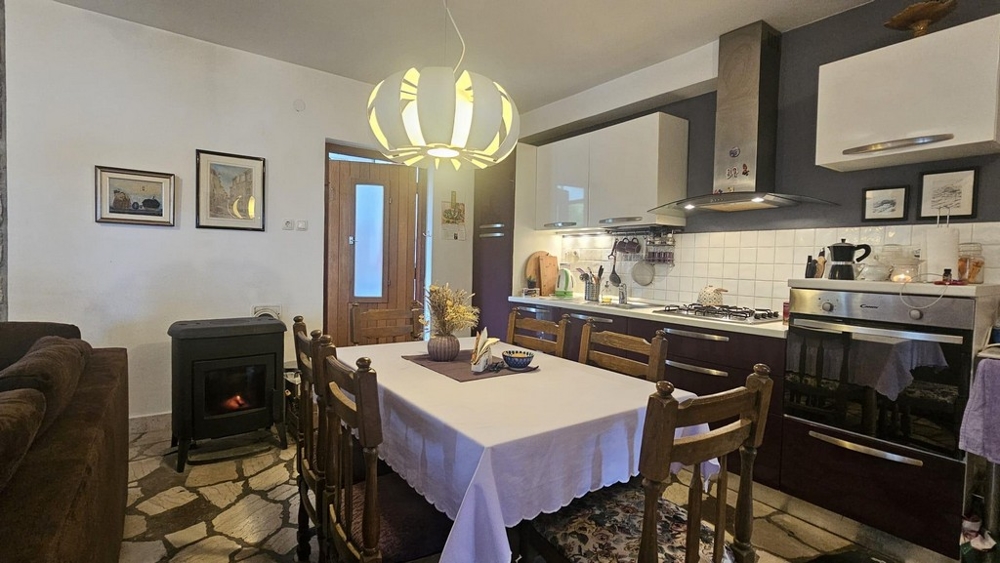Cucina con zona pranzo e stufa a legna