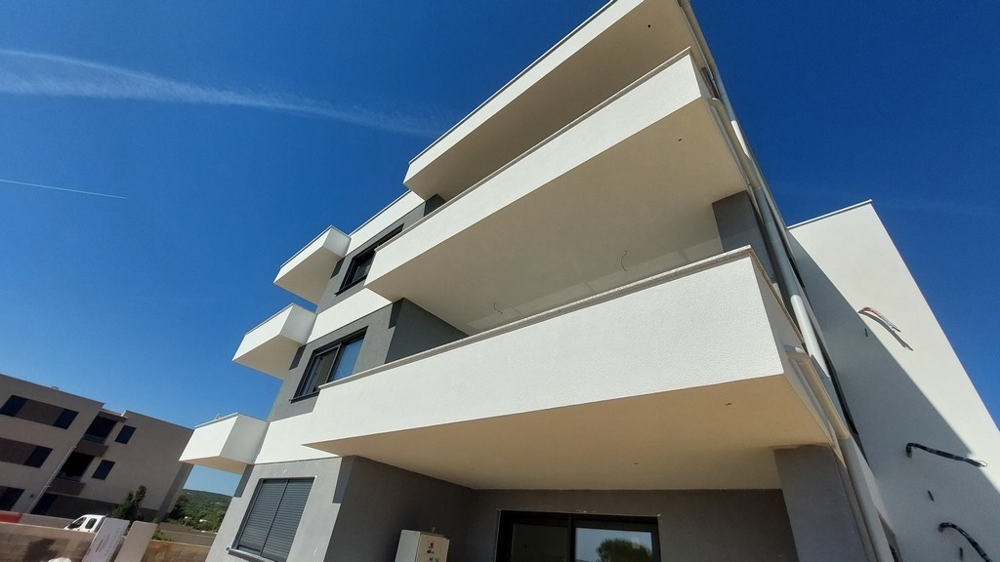 Edificio nuovo bianco con balconi a sbalzo visto dal basso