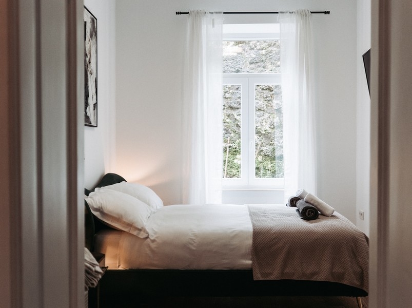 Camera da letto con letto singolo e tende chiare