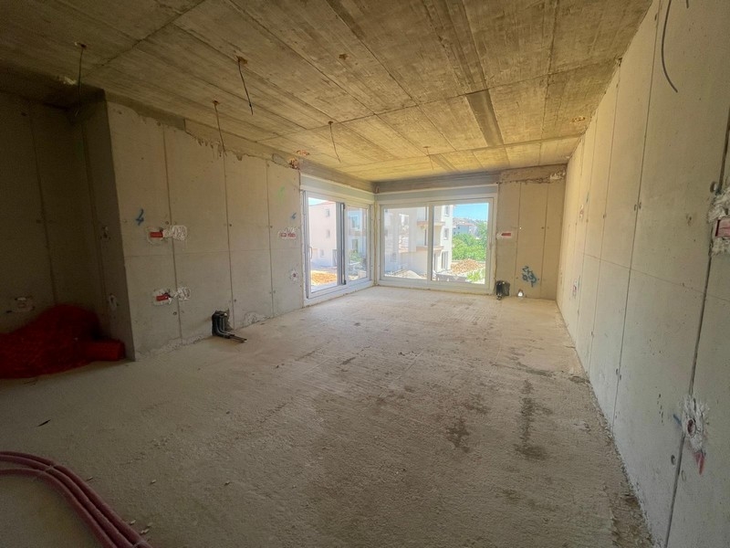 Vista interna della costruzione al grezzo con grandi superfici finestrate