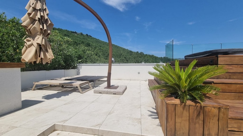Terrazza sul tetto con vasca idromassaggio e lettini prendisole