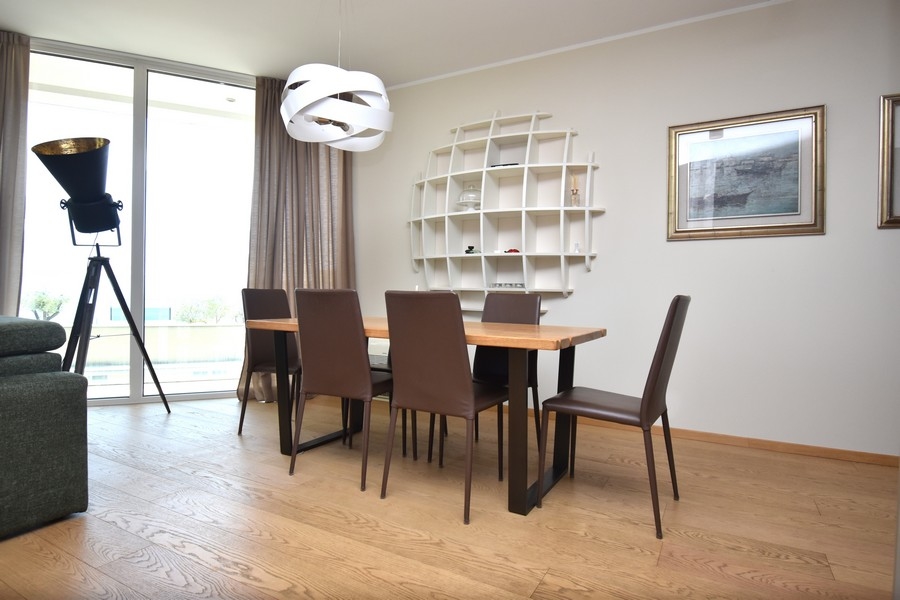 Zona pranzo con grande finestra e design moderno