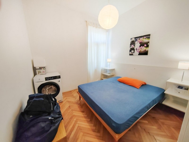 Camera da letto con letto matrimoniale e lavatrice