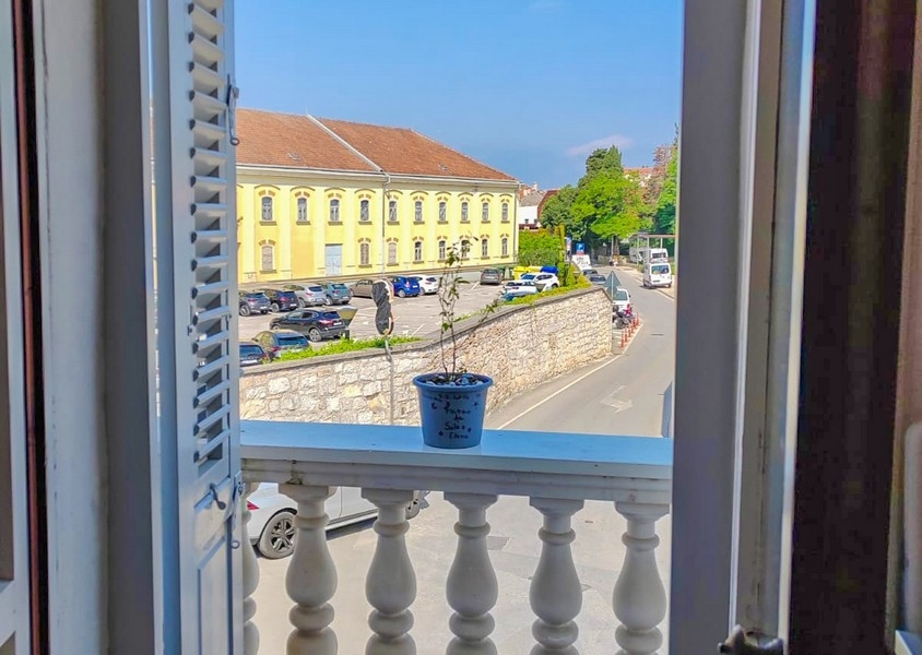 Vista dalla finestra su un edificio giallo e sulla strada