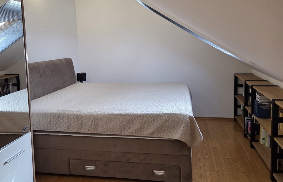 Camera da letto con letto matrimoniale sotto il soffitto spiovente