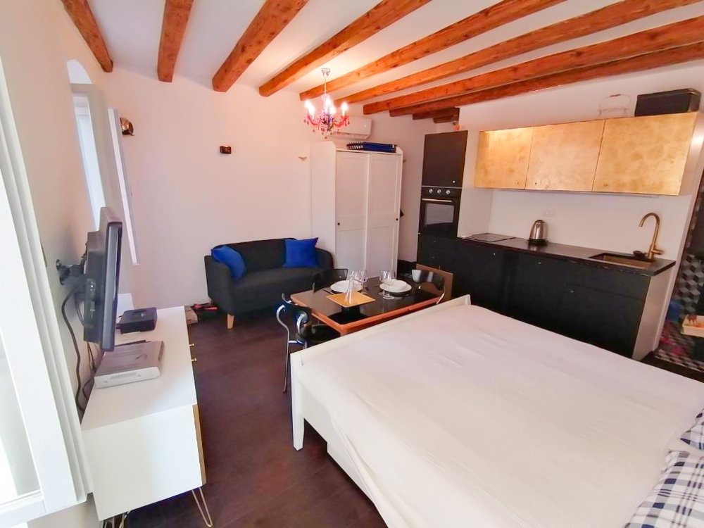 Zona giorno con letto e cucina.
