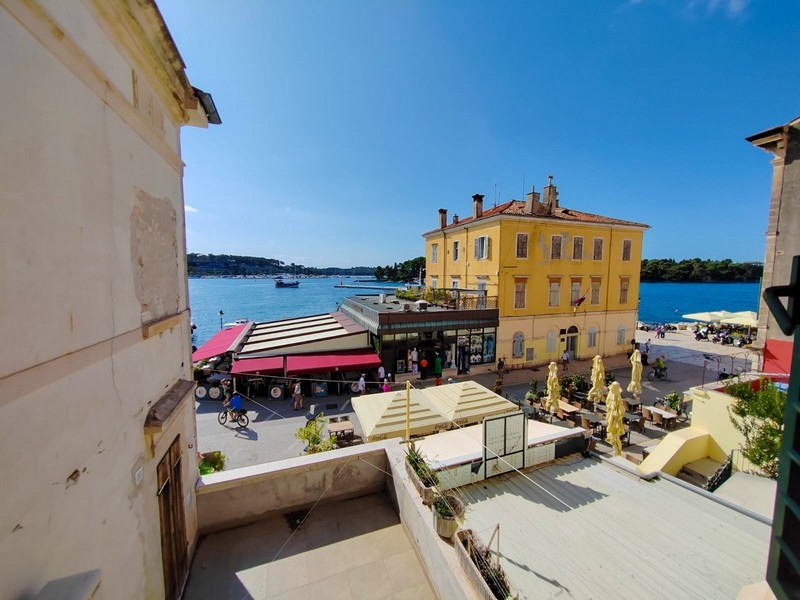 Vista sul lungomare del porto con palazzo giallo e locali