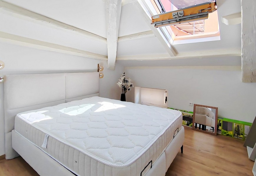 Camera da letto nel sottotetto con letto matrimoniale e finestra sul tetto