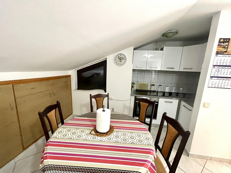 Zona pranzo con tavolo e sedie accanto alla cucina