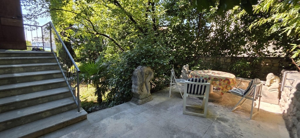 Terrazza con zona salotto e scala verso il giardino