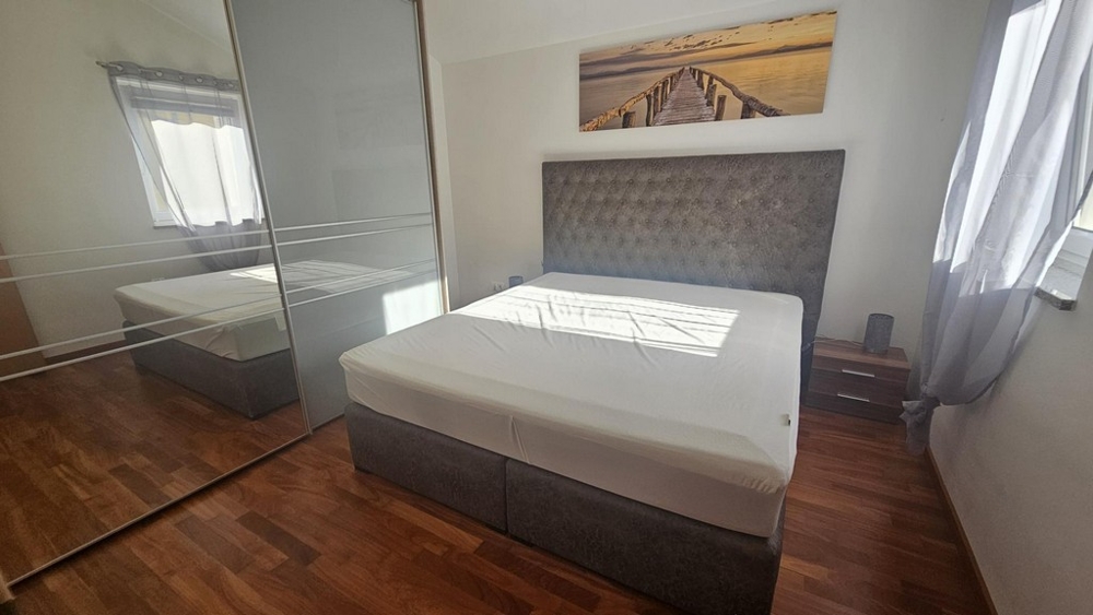 Camera da letto con letto matrimoniale e grande armadio a specchio