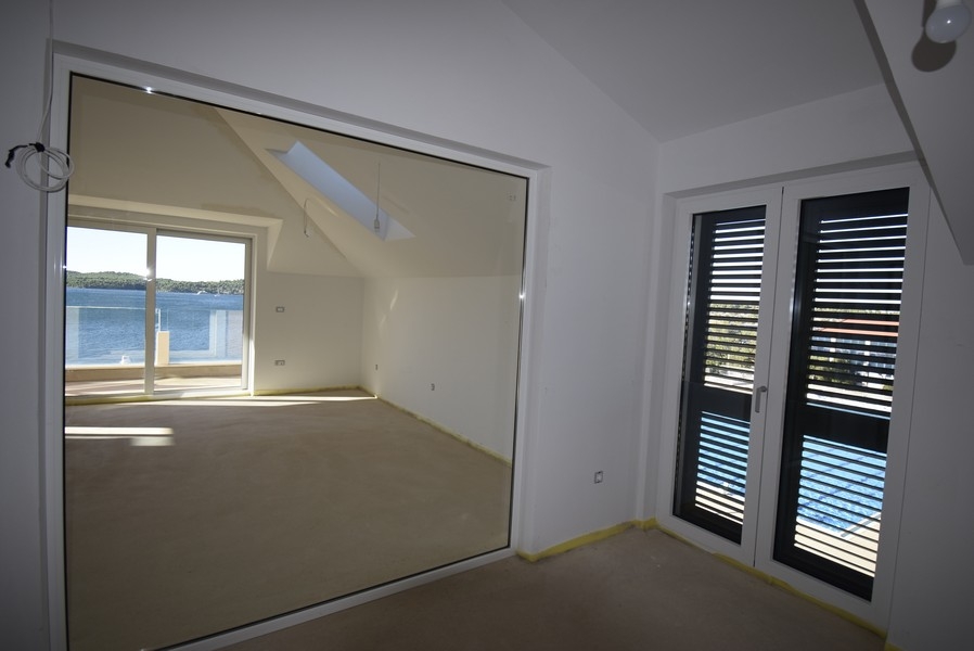 Camera da letto con parete in vetro e accesso al balcone