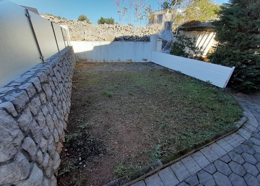 Piccola area giardino con muro in pietra e prato