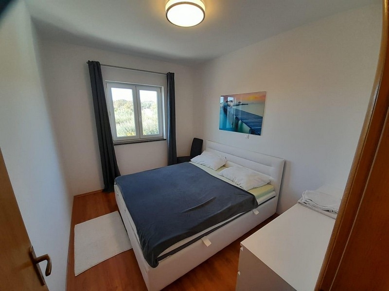 Camera da letto con letto matrimoniale, finestra e quadro alla parete