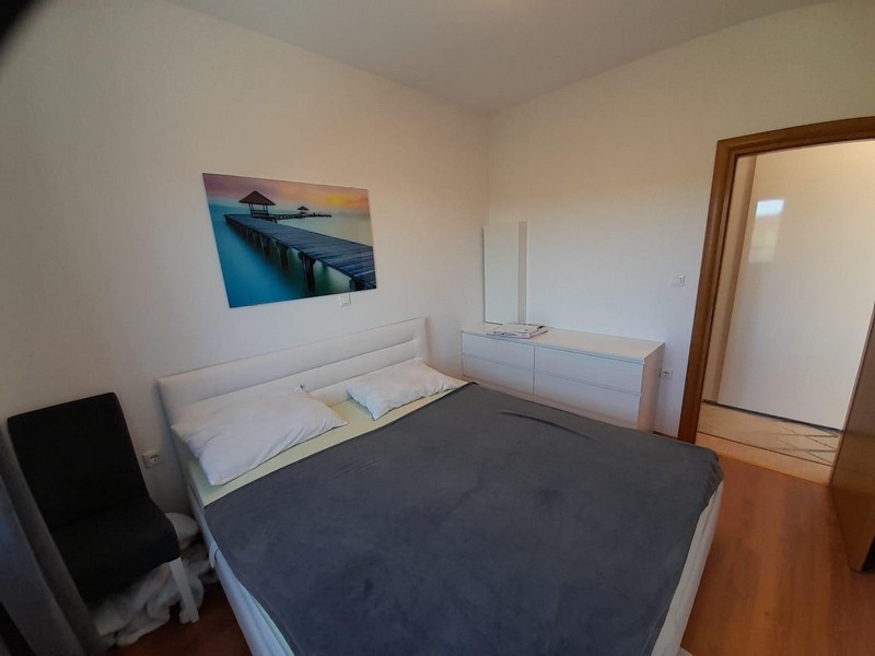 Camera da letto con letto matrimoniale, cassettiera e specchio