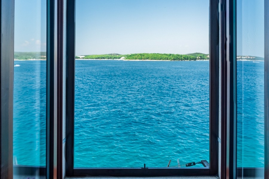Finestra aperta con vista sul mare e sull'isola