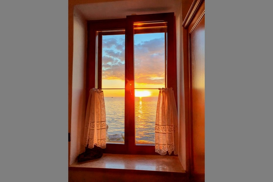 Tramonto sul mare dietro la finestra a riquadri