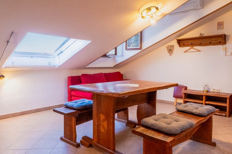 Zona giorno con soffitto mansardato e mobili in legno