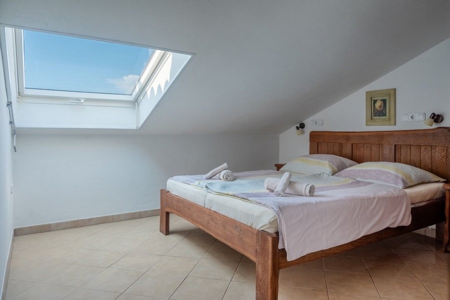 Camera da letto con letto matrimoniale e finestra sul tetto