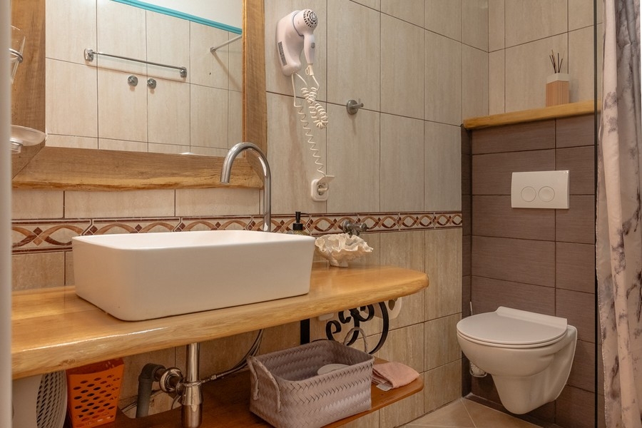 Bagno con doccia e lavabo in legno