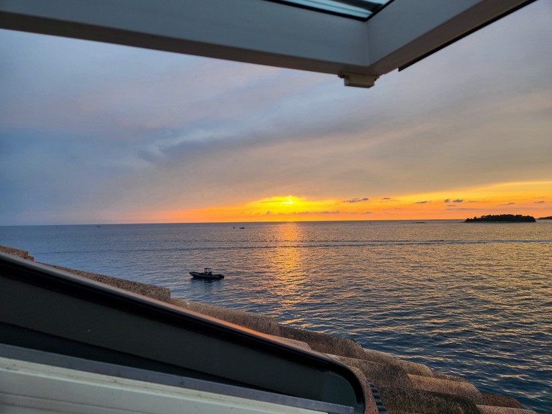 Vista mare e tramonto dalla finestra sul tetto