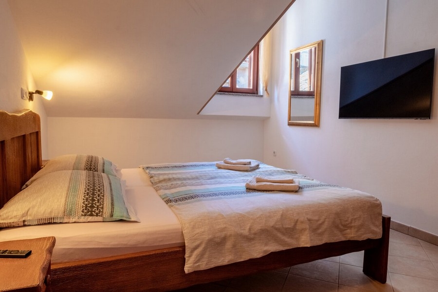 Camera da letto con letto matrimoniale e TV a parete