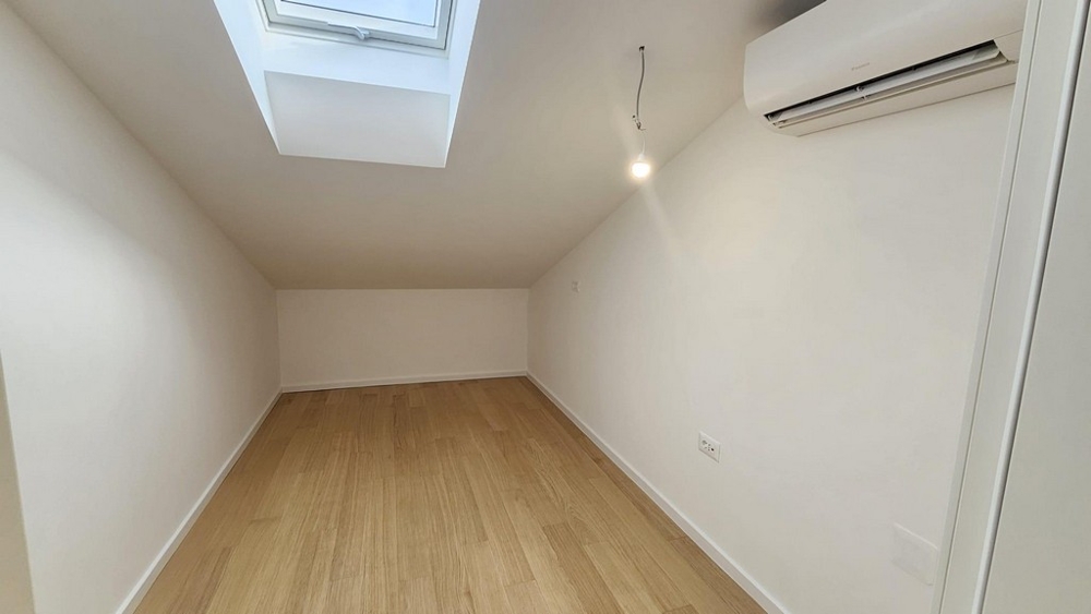 Stanza con soffitto inclinato e finestra sul tetto