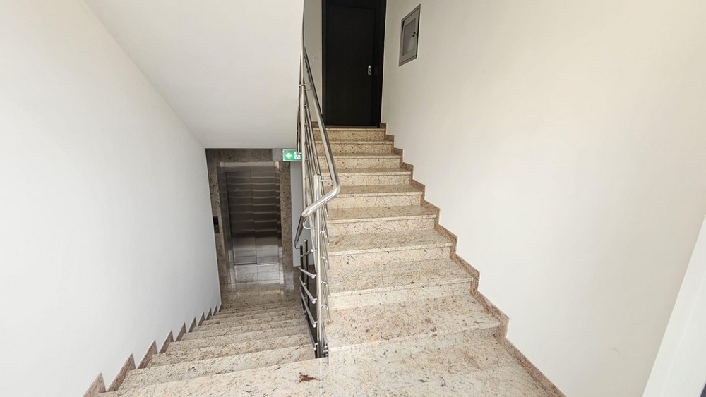 Vano scale con ascensore e gradini in marmo
