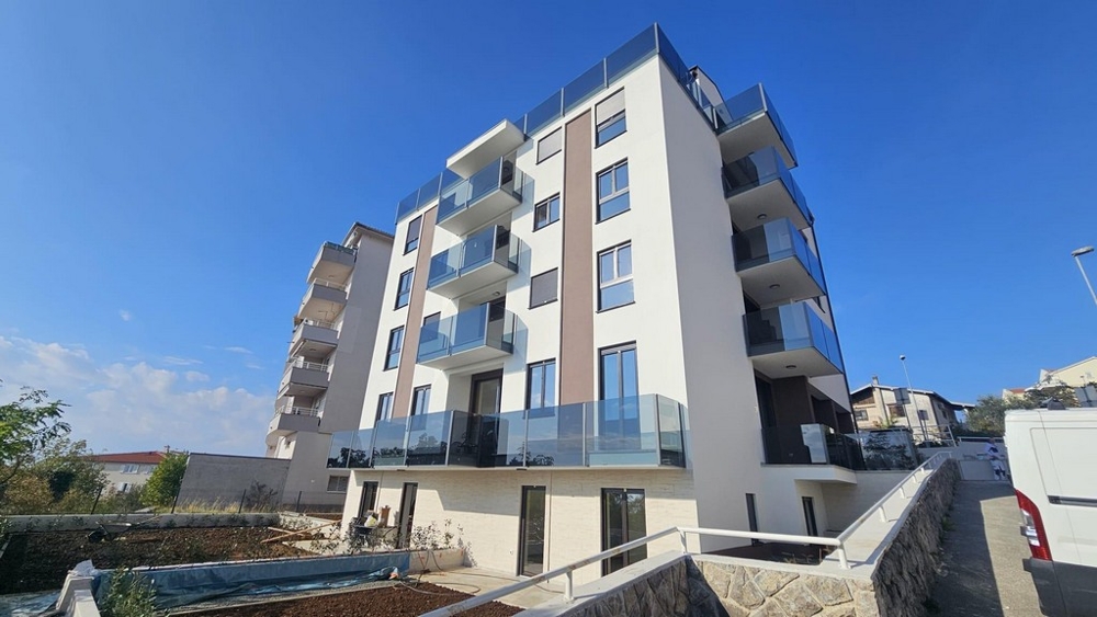 Edificio nuovo a più piani con balconi in vetro sul pendio