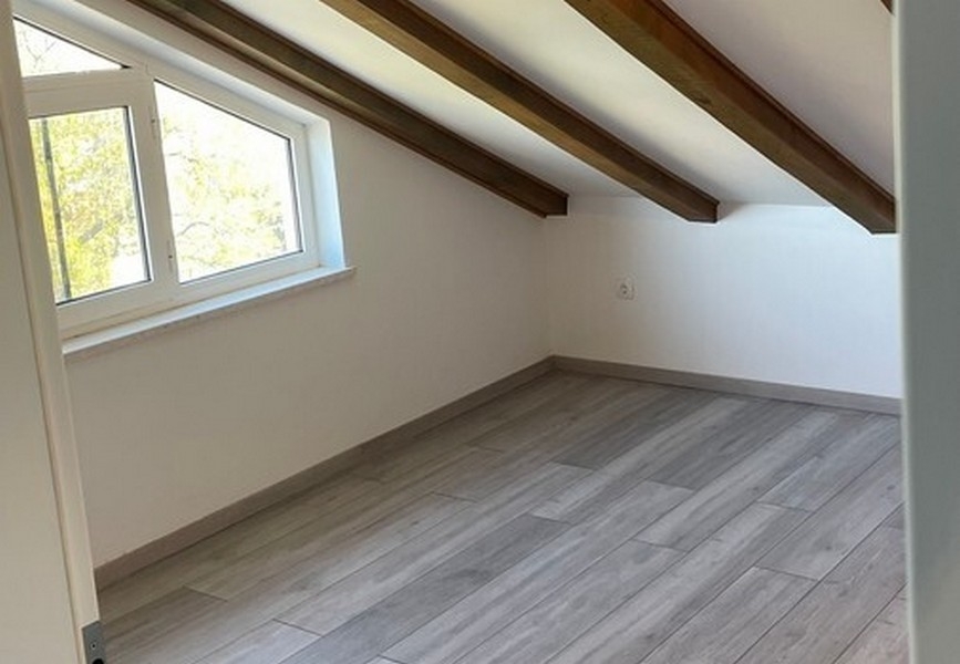 Stanza nel sottotetto con travi del tetto a vista