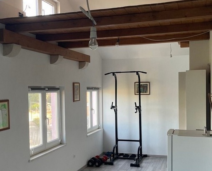 Area fitness sotto le travi in legno nel soggiorno