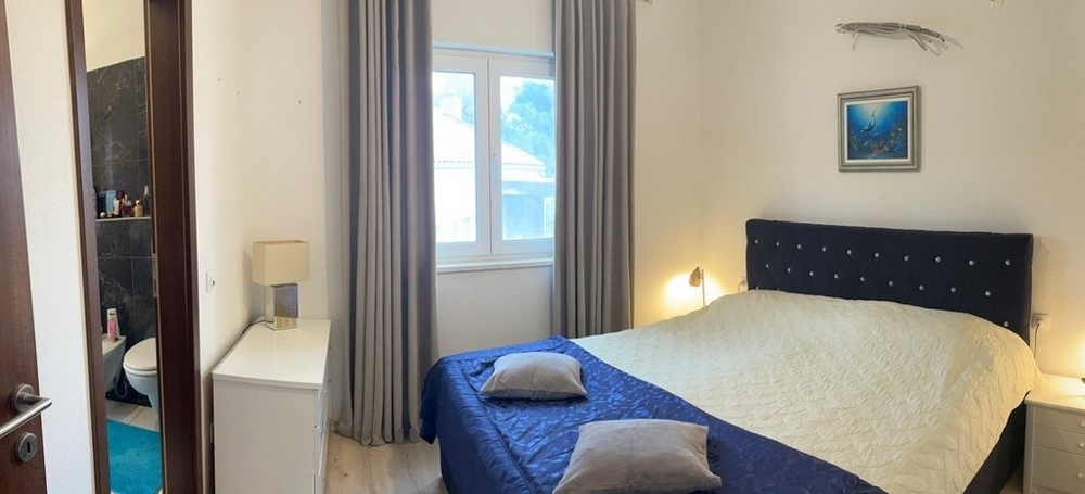 Camera da letto con letto matrimoniale, finestra e accesso al bagno