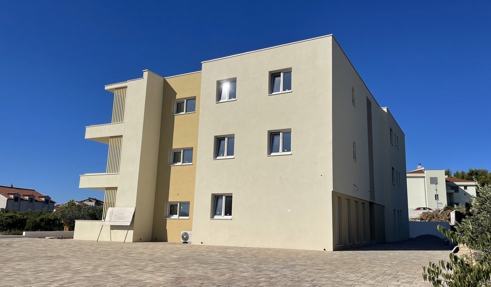 Stanza allo stato grezzo con finestra e vista mare
