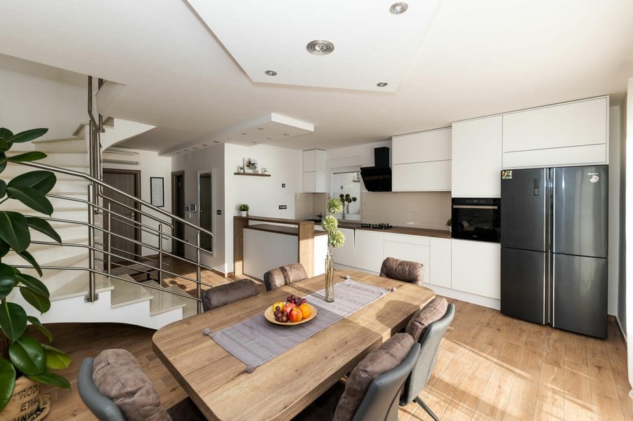 Cucina aperta con zona pranzo e scala verso il piano superiore