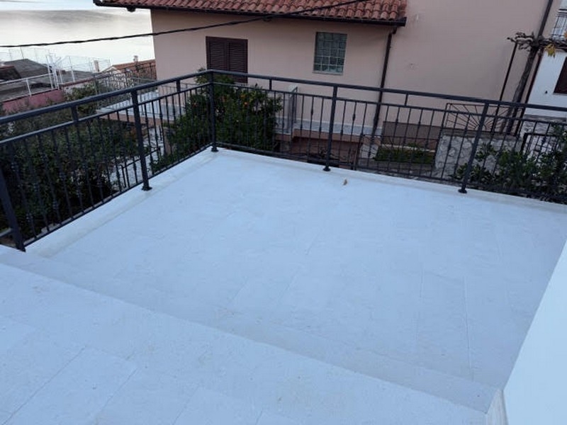 Area terrazza con ringhiera e vista sulla casa vicina