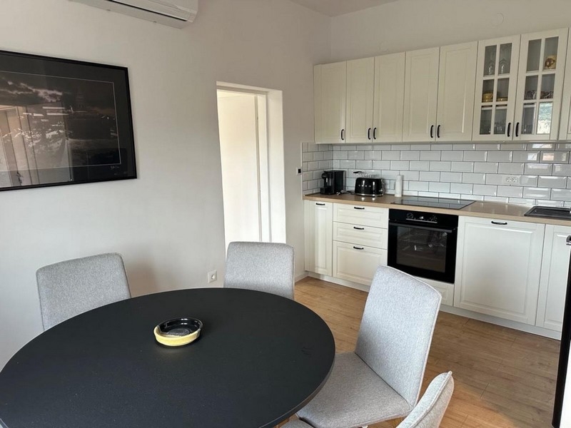 Zona pranzo con tavolo rotondo e cucina moderna