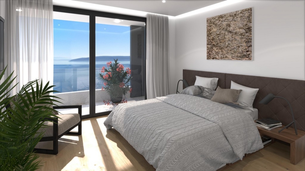 Camera da letto con grande finestra e vista mare