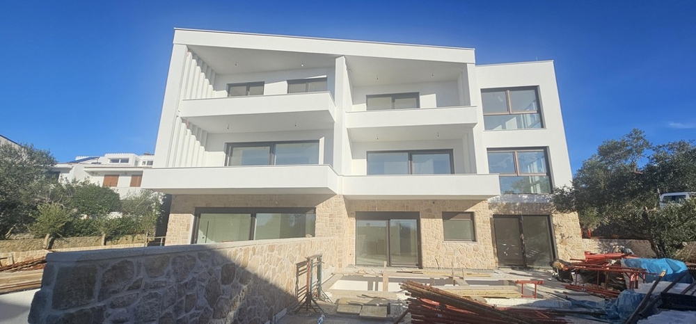 Edificio nuovo con zoccolo in pietra naturale e logge in cantiere