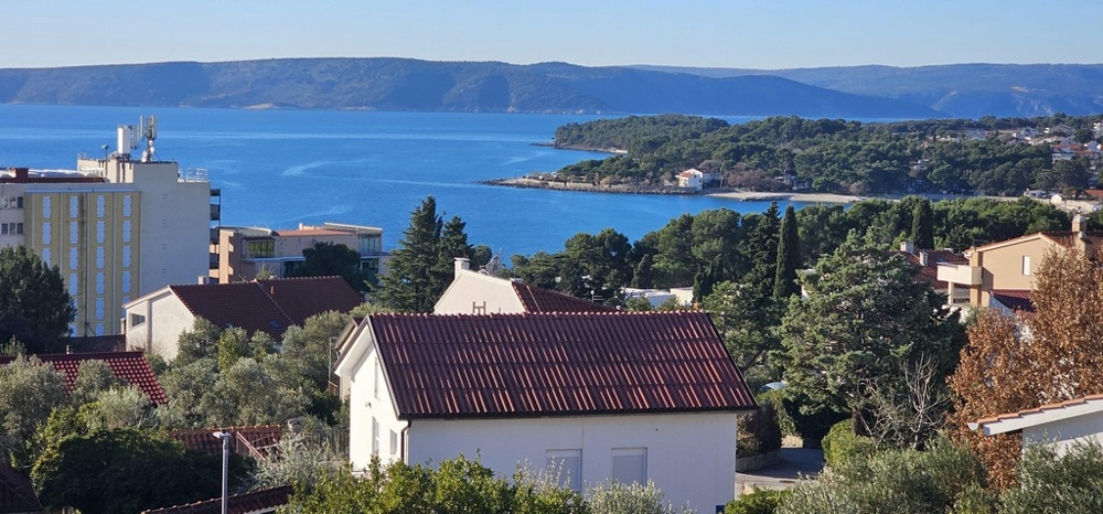 Vista sui tetti e sui pini fino all'ampia baia