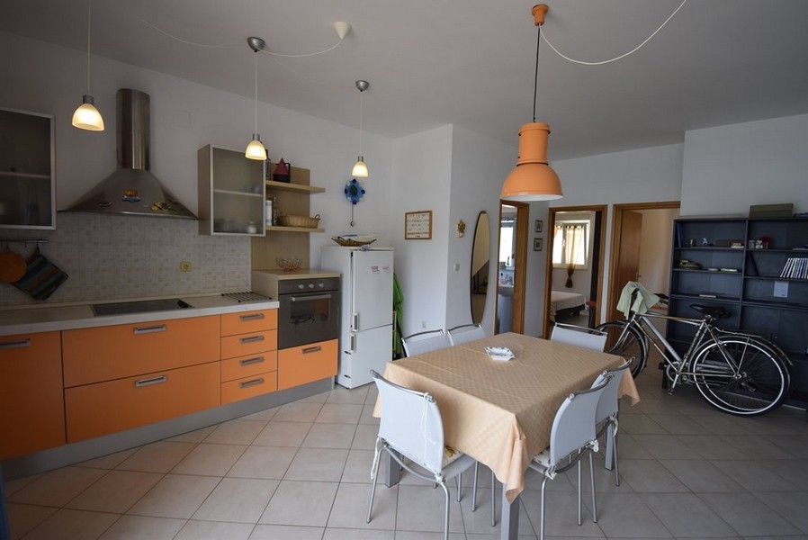 Zona giorno aperta con cucina e posto per biciclette