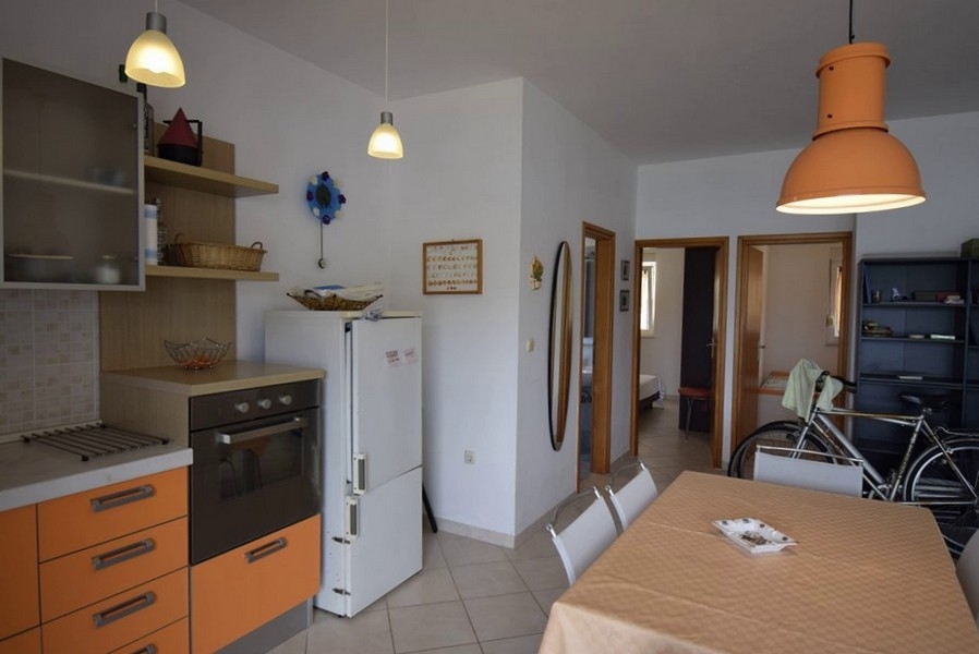 Cucina con elettrodomestici da incasso e vista sulla zona giorno