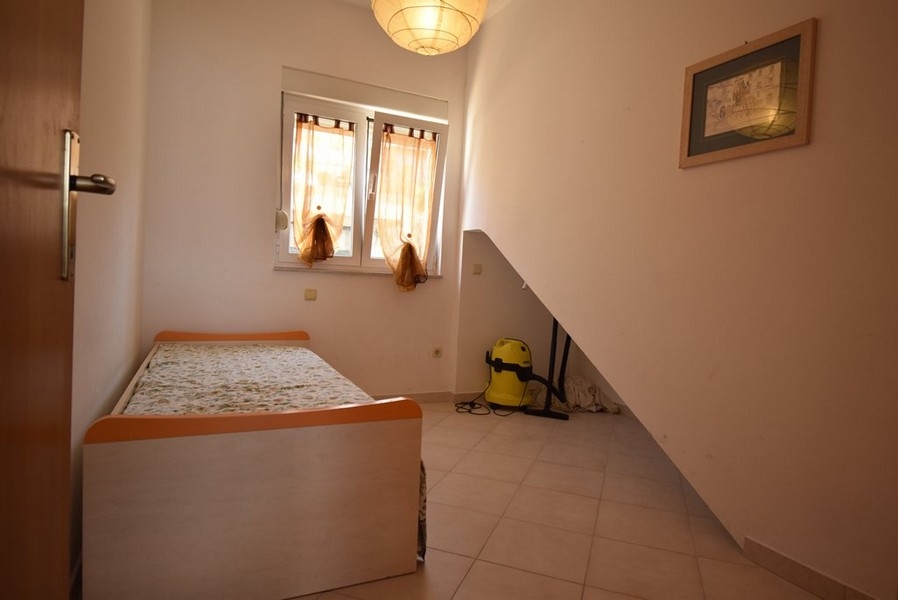 Piccola camera da letto con letto singolo e soffitto spiovente