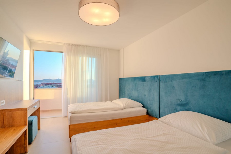 Camera da letto con due letti e accesso al balcone