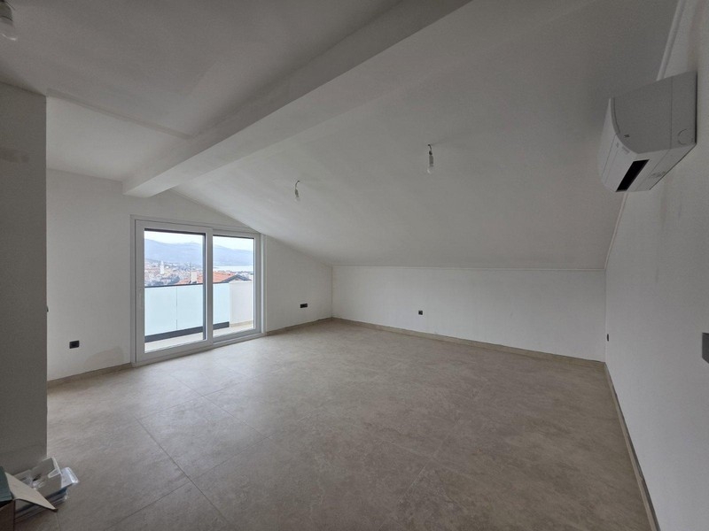 Sottotetto vuoto con porta del balcone e vista sulla baia