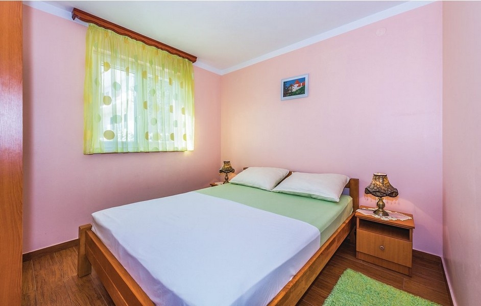 Camera da letto rosa con tenda gialla alla finestra