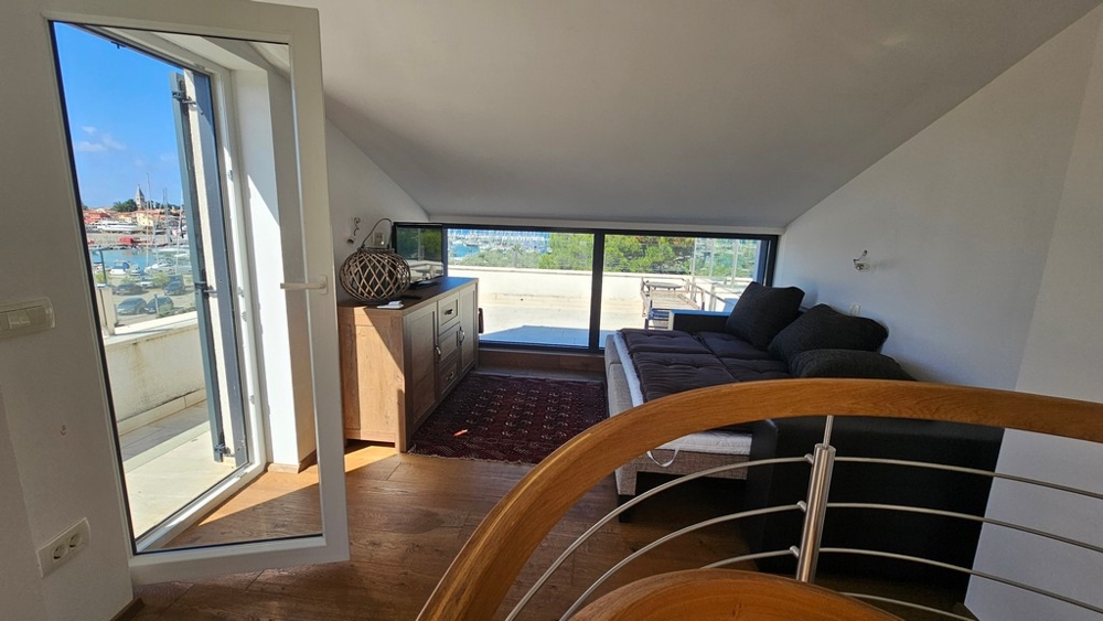 Zona giorno nel sottotetto con accesso alla terrazza sul tetto e vista mare